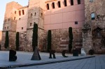 Modern "Barcino" sculpture near Roman wall