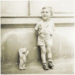 Old photo showing a child with a teddy bear